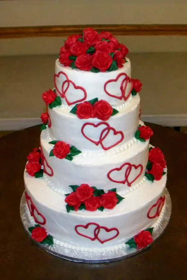 Three tier cake with red hearts and roses decorating